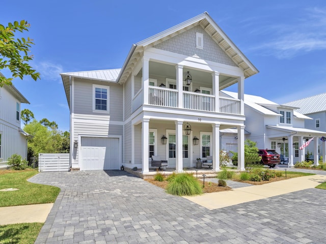 90 White Cottage Rd, Santa Rosa Beach, FL 32459 - greek revival house with a standing seam roof, a porch, a garage, a balcony, and decorative driveway