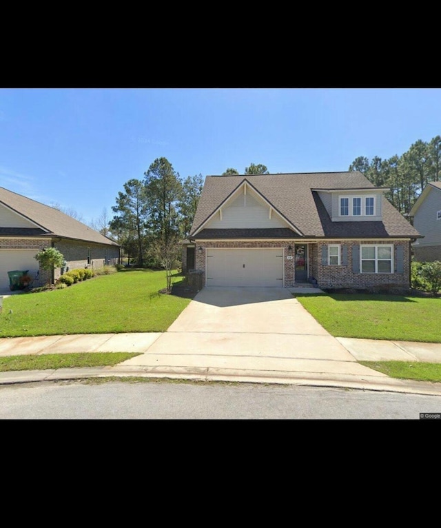 view of front of house featuring a garage, driveway, and a front lawn