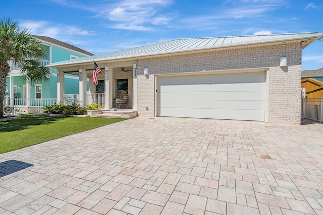 view of front of home featuring a garage, covered porch, and a front lawn