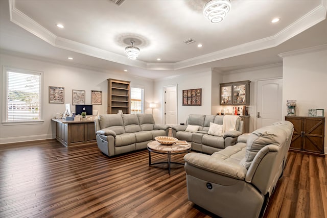 living room featuring dark hardwood / wood-style floors, ornamental molding, and a raised ceiling