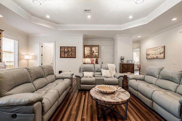 living room featuring ornamental molding, dark hardwood / wood-style floors, and a tray ceiling