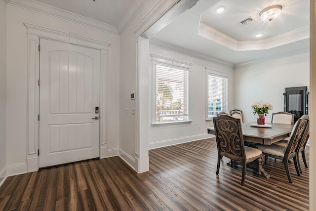 dining room with dark hardwood / wood-style floors, ornamental molding, and a raised ceiling