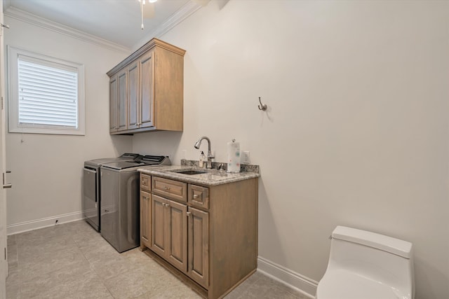 washroom featuring separate washer and dryer, sink, crown molding, and cabinets