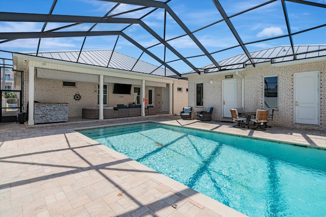 view of swimming pool featuring outdoor lounge area, a patio area, and glass enclosure