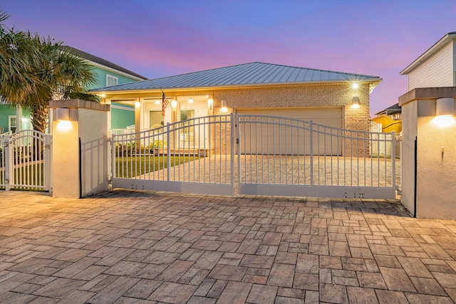 gate at dusk featuring a garage