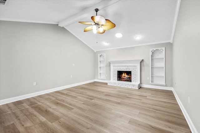 2185 Calle De Castelar, Navarre, FL 32566 - unfurnished living room with vaulted ceiling with beams, ornamental molding, ceiling fan, a brick fireplace, and light hardwood / wood-style flooring