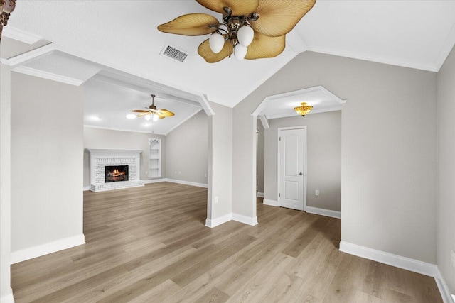 2185 Calle De Castelar, Navarre, FL 32566 - unfurnished living room with built in shelves, light hardwood / wood-style floors, vaulted ceiling, and a brick fireplace