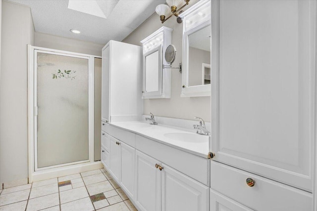 2185 Calle De Castelar, Navarre, FL 32566 - bathroom with tile patterned flooring, a skylight, vanity, a textured ceiling, and walk in shower