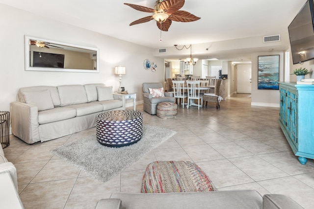 living room with light tile patterned floors and ceiling fan with notable chandelier