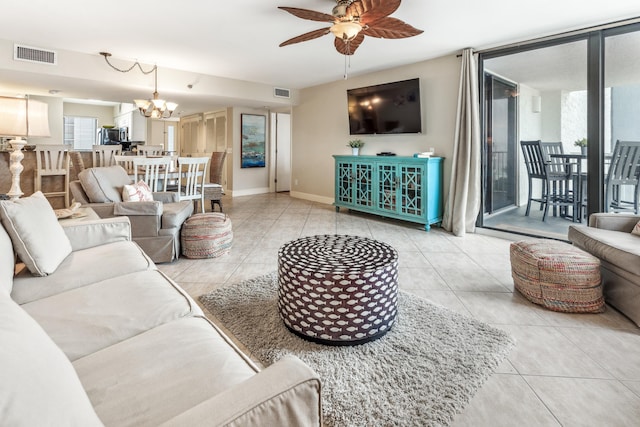 tiled living room with ceiling fan with notable chandelier