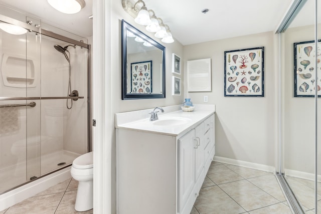 bathroom with tile patterned flooring, vanity, toilet, and walk in shower