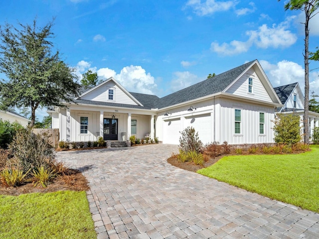 view of front of house with a garage, a front yard, and a porch