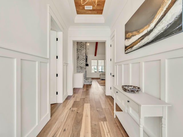 interior space featuring a raised ceiling and light wood-type flooring