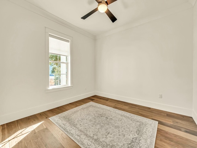 spare room with crown molding, wood-type flooring, and ceiling fan