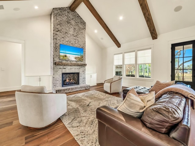 living room featuring beam ceiling, a fireplace, high vaulted ceiling, and wood-type flooring