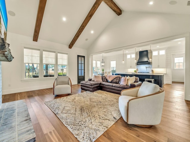 living room featuring beam ceiling, high vaulted ceiling, and light hardwood / wood-style flooring