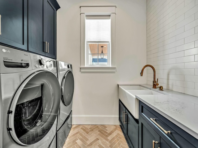 washroom with cabinets, sink, and independent washer and dryer