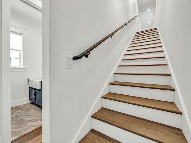 stairway featuring parquet flooring