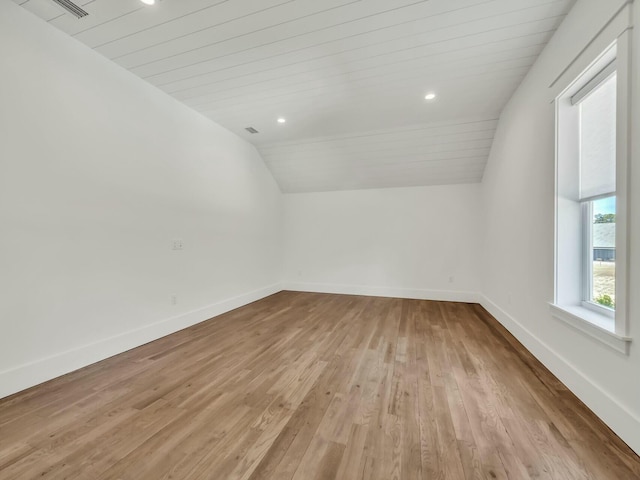 additional living space with vaulted ceiling, wooden ceiling, and light hardwood / wood-style flooring