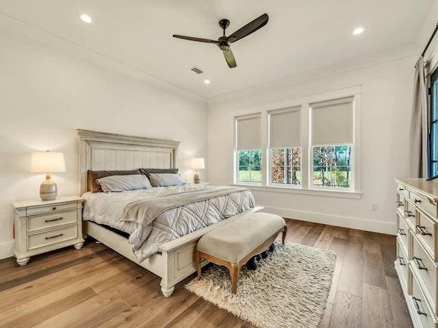 bedroom with crown molding, light hardwood / wood-style flooring, and ceiling fan