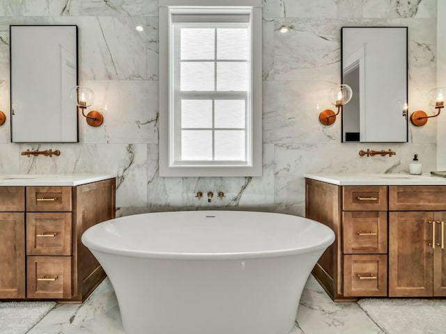 bathroom featuring a washtub, vanity, and a healthy amount of sunlight