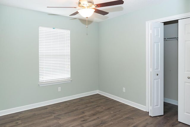 unfurnished bedroom with a closet, dark hardwood / wood-style floors, and ceiling fan