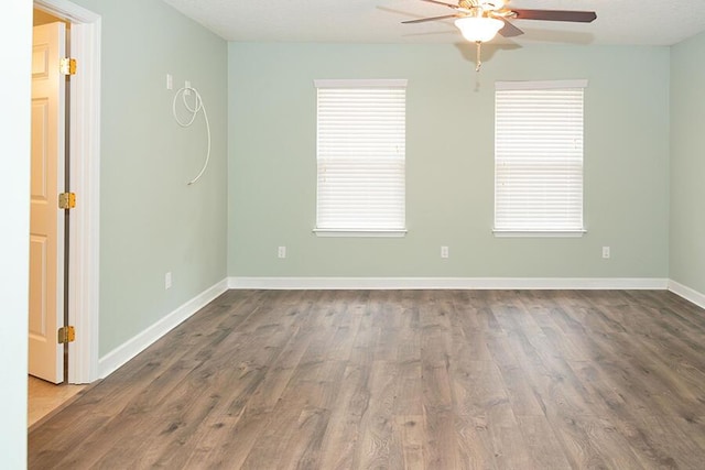 empty room with a healthy amount of sunlight, hardwood / wood-style floors, and ceiling fan