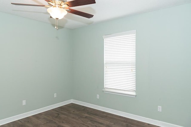 spare room featuring dark hardwood / wood-style flooring, ceiling fan, and a healthy amount of sunlight