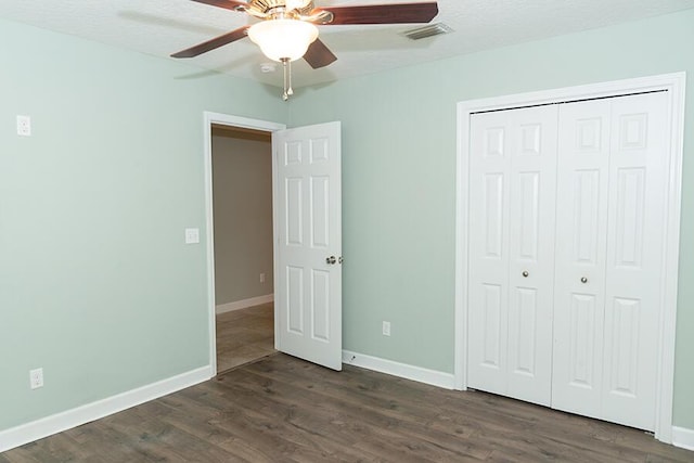 unfurnished bedroom featuring ceiling fan, dark hardwood / wood-style floors, and a closet