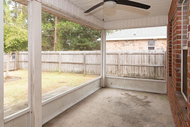 unfurnished sunroom featuring ceiling fan and plenty of natural light