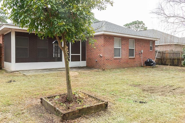 back of property with a sunroom and a lawn