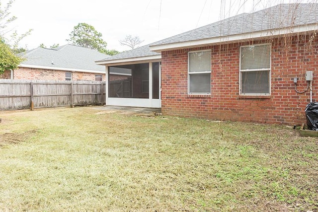 back of house featuring a sunroom and a lawn