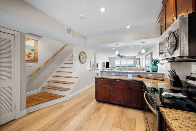 kitchen featuring visible vents, light wood-type flooring, a peninsula, appliances with stainless steel finishes, and open floor plan