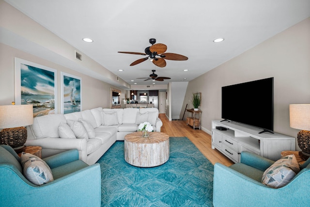 living area with light wood-style flooring, recessed lighting, visible vents, and baseboards