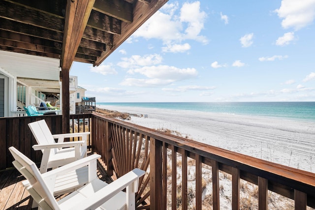 balcony featuring a view of the beach and a water view