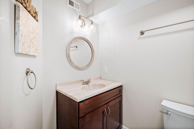 bathroom featuring visible vents, toilet, and vanity