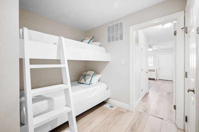 bedroom featuring wood finished floors, visible vents, and baseboards