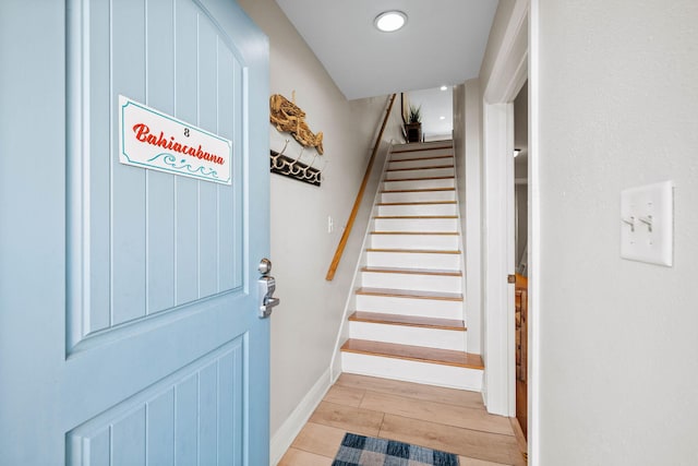 stairway featuring baseboards and wood finished floors