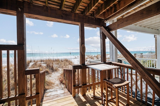 deck featuring a view of the beach and a water view