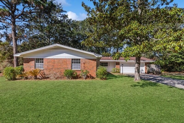 single story home featuring a garage, driveway, a front lawn, and brick siding