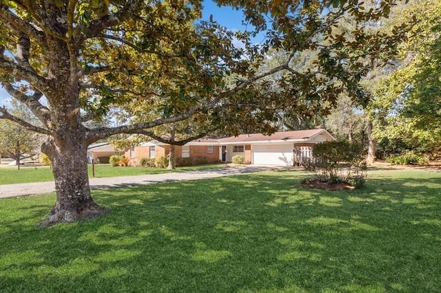 ranch-style home featuring a garage, driveway, and a front lawn