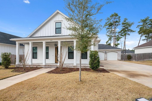 view of front of home featuring a garage, a front yard, and covered porch