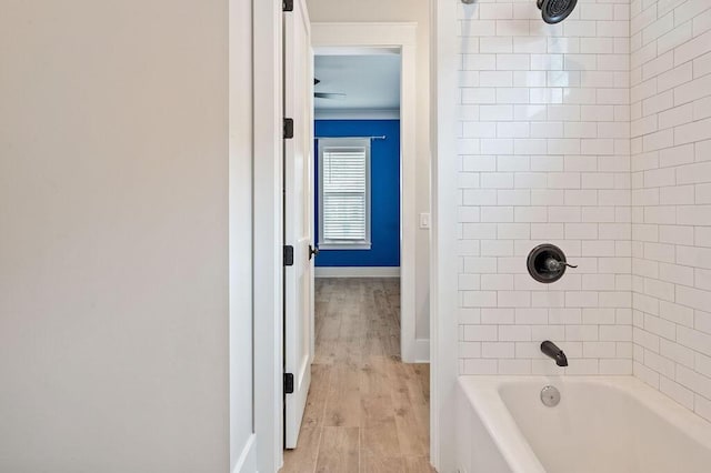 bathroom with tiled shower / bath combo and wood-type flooring