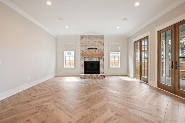 unfurnished living room with light parquet floors, ornamental molding, and french doors