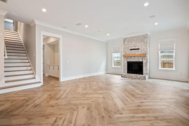 unfurnished living room with a fireplace, crown molding, plenty of natural light, and light parquet flooring