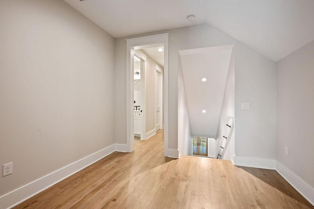 bonus room with lofted ceiling and light wood-type flooring