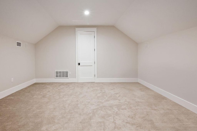 additional living space with lofted ceiling and light carpet