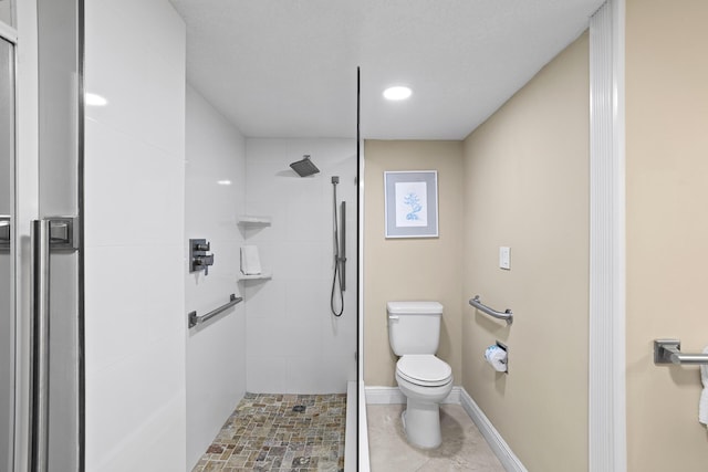 bathroom featuring baseboards, toilet, and walk in shower