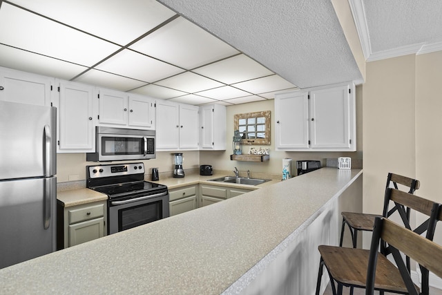 kitchen featuring stainless steel appliances, a breakfast bar, a sink, and light countertops