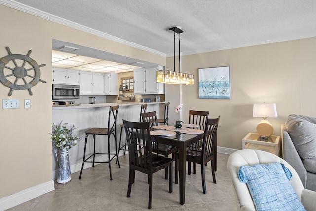 dining room with crown molding, a textured ceiling, visible vents, and baseboards